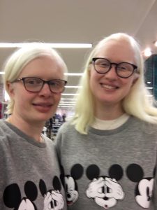 Sarah Leiter and Aure Aflalo taking a selfie together whilst wearing a grey jumper which has mickey mouse on it. Both are smiling to the camera.