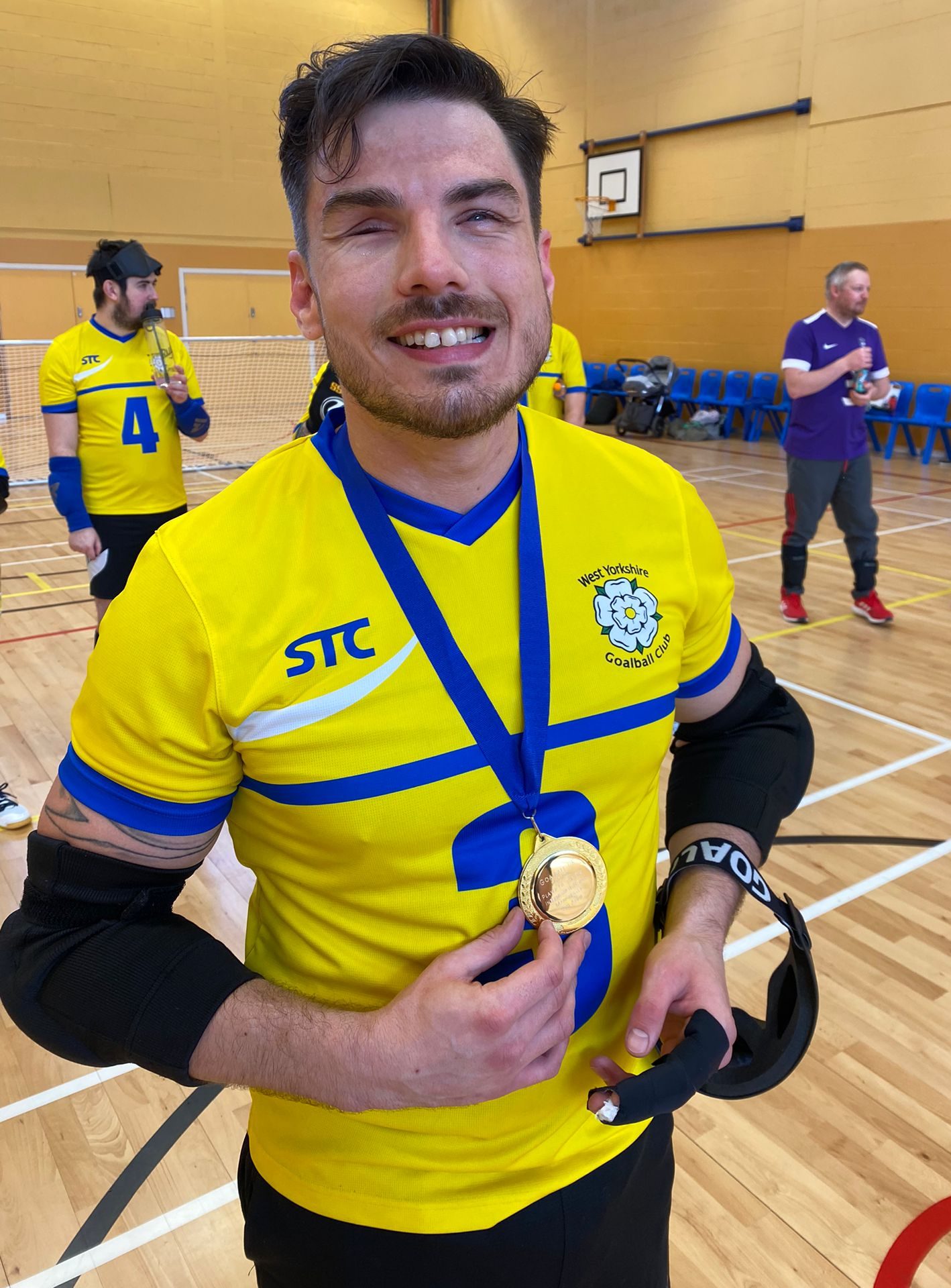 Josh Windle smiling to the camera with a massive grin with his player of the day medal, whilst wearing his yellow West Yorkshire jersey.
