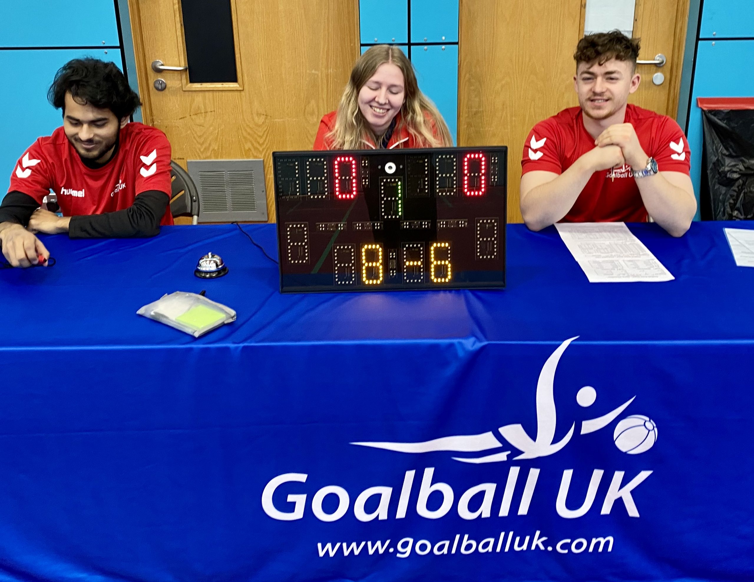 3 activators in red tops sat at the officials table at a tournament in Sheffield