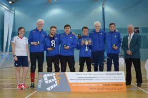 The 2017 Winchester Goalfix Cup winning team with 5 players in Winchester jackets standing together with their medals and trophies. Along with coach Alex Bunney and former Goalball UK staff member Becky Ashworth/ 