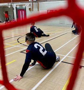 Freya on court for RNC Hereford, with the camera looking through the goalball goal netting.