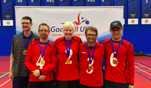 Lancashire Lions group photo at a novice tournament with 4 players wearing their gold medals, with coach Matt Woofe to the left of the team.