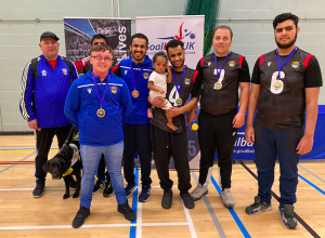 Birmingham silver medallists with coaches Mo an Conna. Player Sal is holding a future goalball star with his baby daughter.
