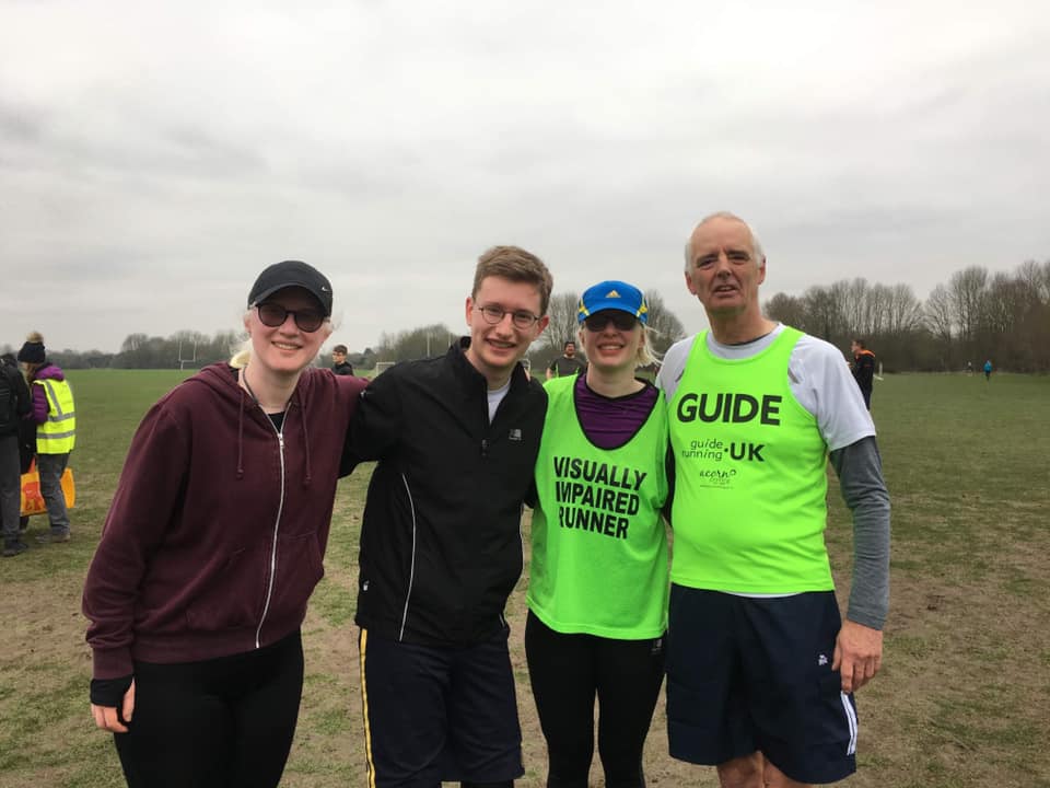 4 people taking part in a park run, they have come together beforehand (as they don't look too sweaty!) for a picture. Left to right: Aure, Andrew, Sarah, and a guide runner (apologies we don't know his name!).