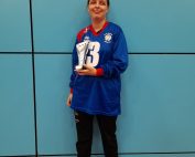 Klaudia Orzel standing in a blue South Yorkshire goalball jersey, and black tracksuit bottoms holding a silver trophy.