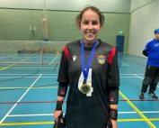 Laura Brooks wearing a black Birmingham jersey, wearing a Player of the Day medal she won at an Intermediate South Matchday! Laura is smiling proudly to the camera.