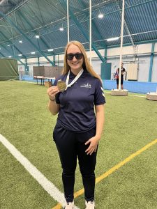 Samantha Gough holding her bronze medal from the European Para Youth Games, whilst wearing her navy blue Great Britain polo shirt.