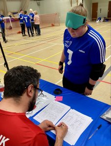 a Cambridge player checking the results sheet at the officials table