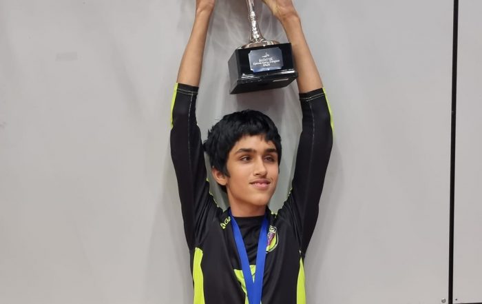 Daniel White - Croysutt Warriors. Daniel is stood with his arms up holding a trophy