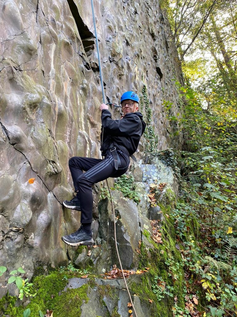 Harry tries abseiling at FTNGA Harry has a go at abseiling. He is wearing a helmet and smiling at the camera.