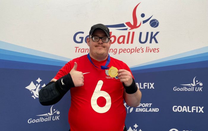 Player of the day Joe Scott smiles at the camera with a thumb up and holding his medal