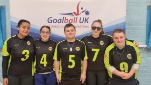 The Croysutt Warriors team smiling for a photo in front of a Goalball UK banner