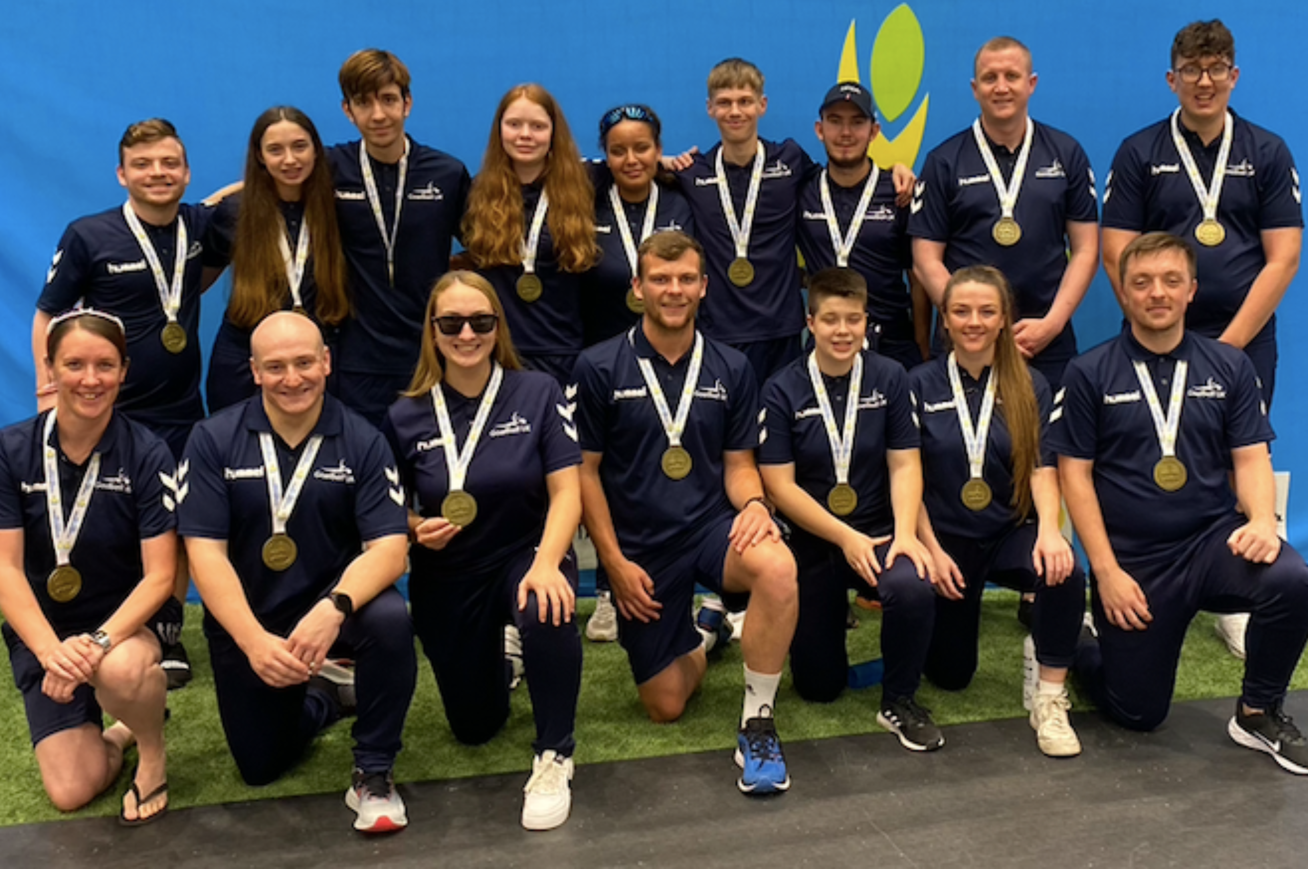 The squad at the European Para Youth Games 2022 all wearing their bronze medals in a group pphoto with the front half kneeling and back half standing