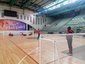 GB Men players training in a sports hall with three coaches.