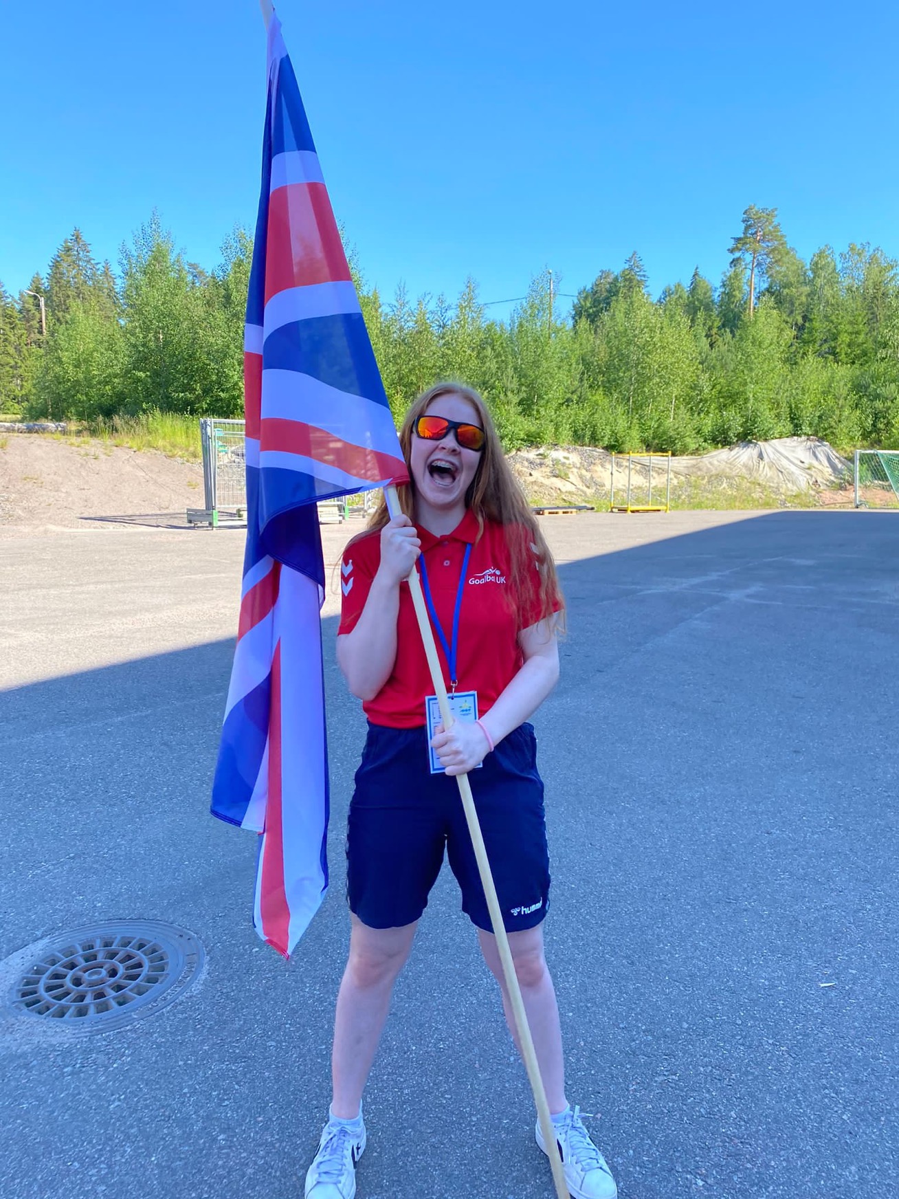 Chelsea holding a Union Jack flag and grinning for the camera