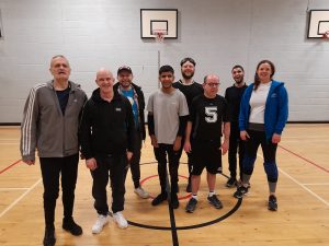 Post Glasgow goalball club session, with all participants standing together in a sports hall.