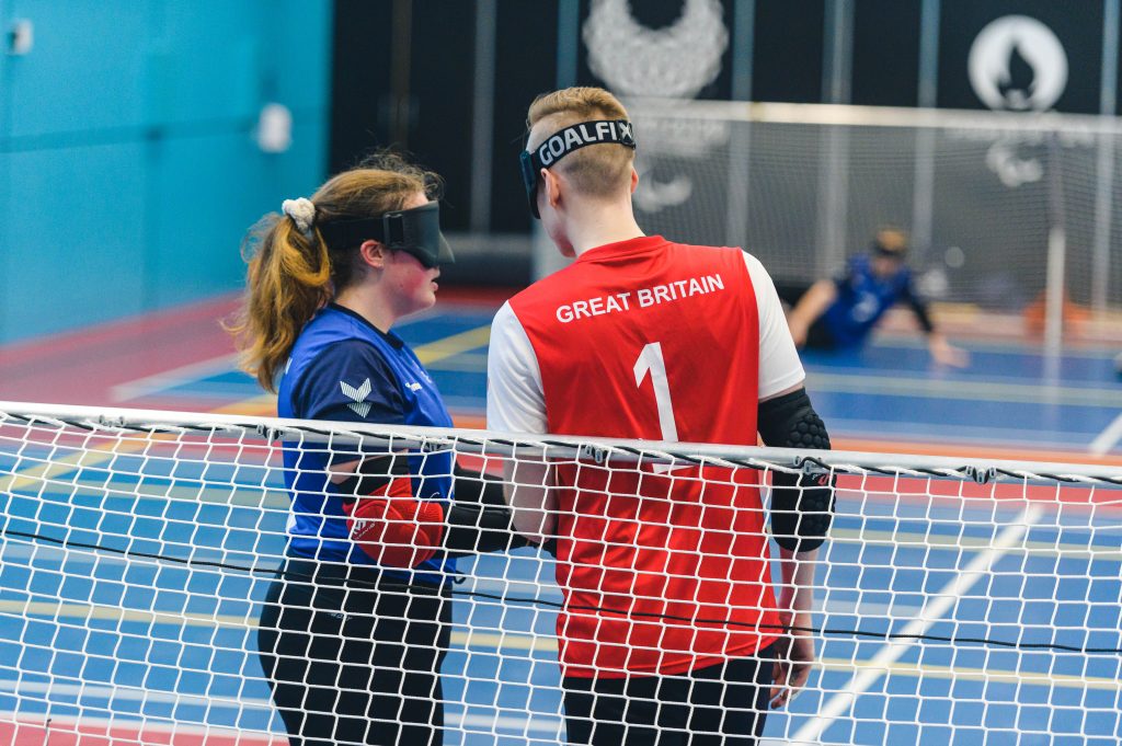 During a game Lois, a GB Women player speaks to Stuart, a GB Men player at the goal