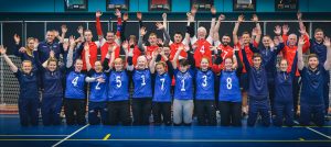 GB men, women and staff are stood in a group formation facing the camera with their