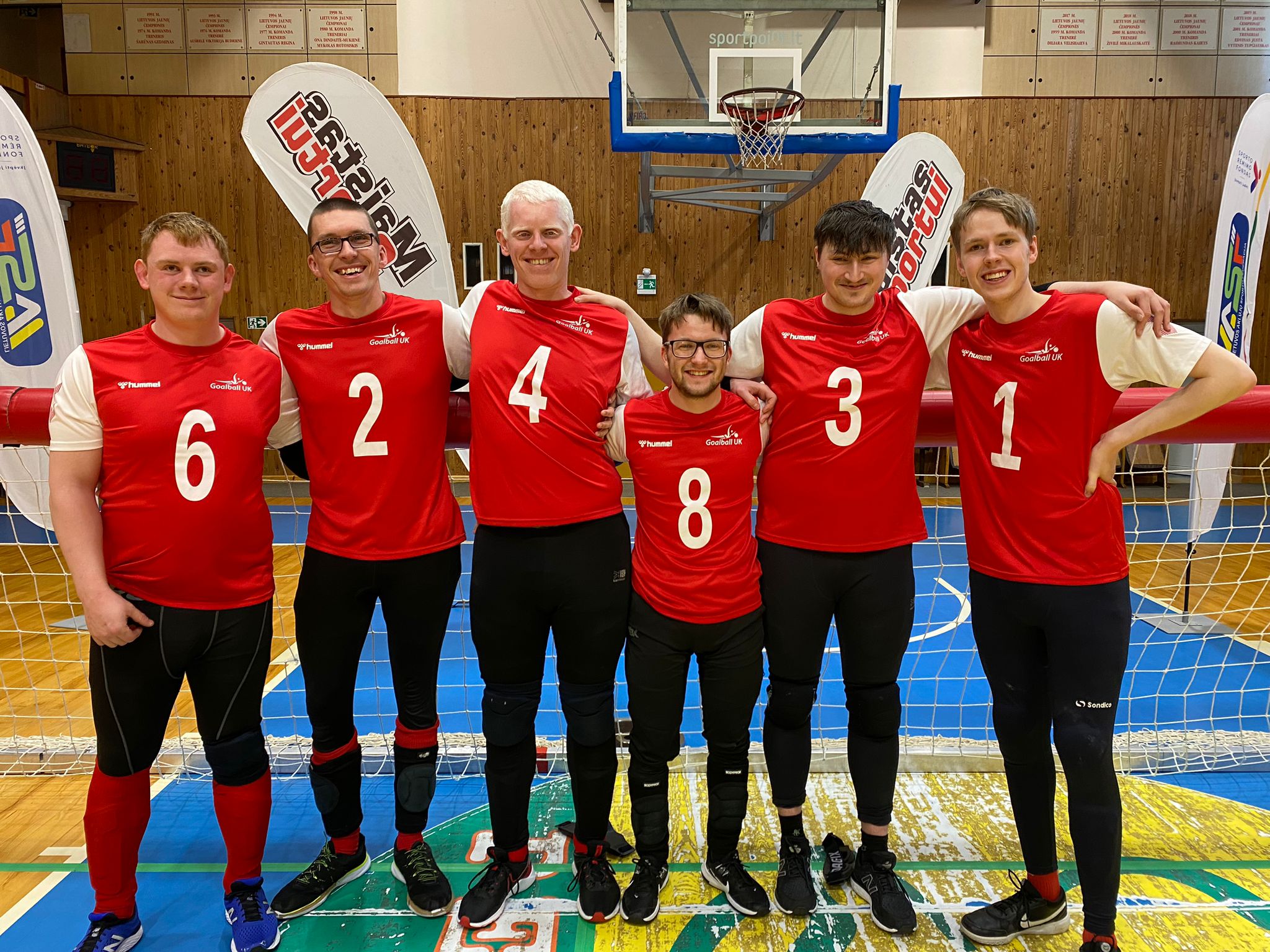 GB Men pose for a smily group photo in Lithuania wearing their red GB kit