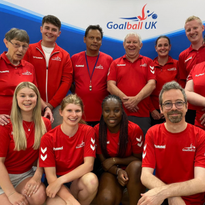 Group photo of a set of volunteers in red official Goalball UK t shirts