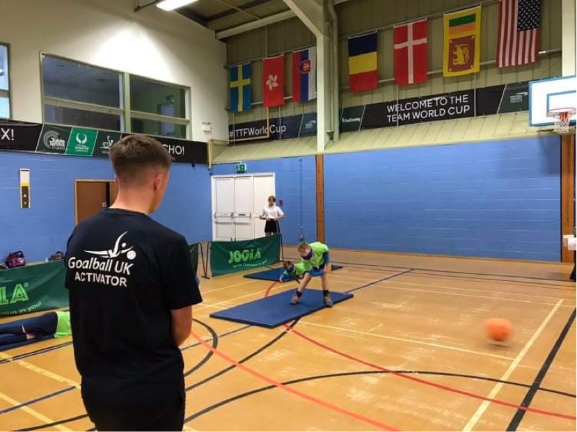 A young Alex Cockerham oversees an indoor goalball game