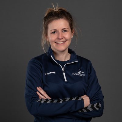 Becky Ashworth Great Britain headshot. Becky is in front of a grey background whilst wearing a navy blue Goalball UK jacket.