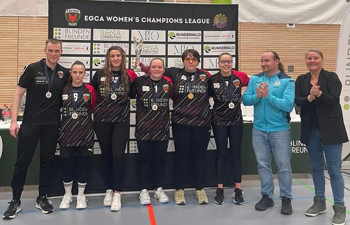 Füchse Berlin squad photo after winning the final of the 2025 Women's Champions League! All players and coaches are standing together in their jerseys, big smiles all round!