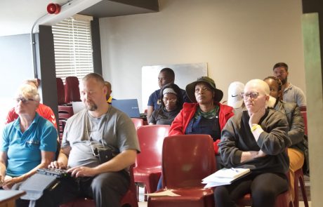 A group of coaches sat in chairs listening to a presentation