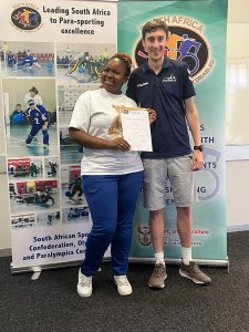 Alex Bunney presenting a certificate to a female in a white tshirt