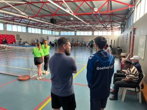 Alex taking to a coach behind the goal in a sports hall.