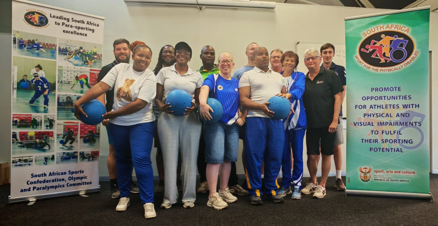 A group stands in front of two banners promoting para-sport in South Africa, including the South African Sports Confederation and Olympic and Paralympics Committee, and messages supporting athletes with physical and visual impairments.