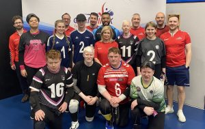 Group picture with Referees and players in front of a goalball UK banner