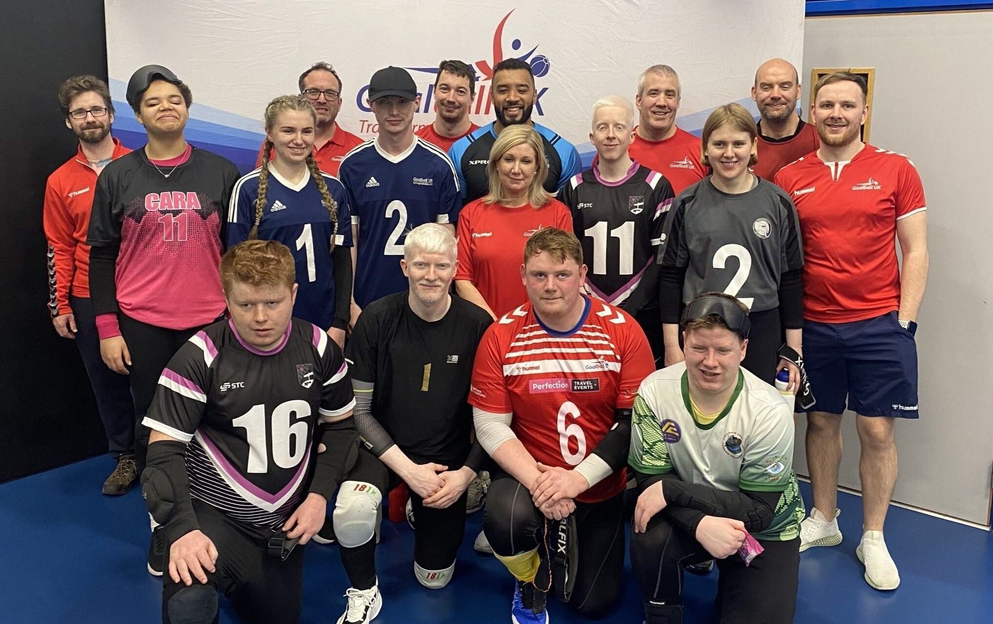 Group picture with Referees and players in front of a goalball UK banner