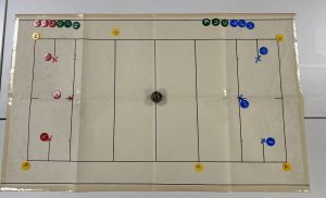 court with tactile markings and counters representing players on a table cloth
